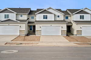 Craftsman house featuring board and batten siding, concrete driveway, stone siding, and an attached garage