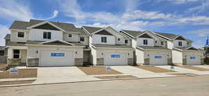 Craftsman house with a residential view, driveway, a garage, board and batten siding, and stone siding