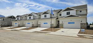 View of front of property with driveway, a residential view, and a garage