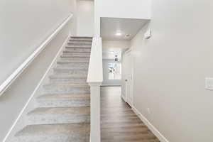 Staircase with wood finished floors and baseboards