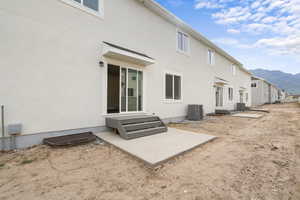Back of house with a patio, a mountain view, and stucco siding