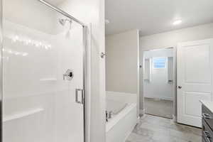 Full bath with vanity, a bath, a shower stall, and a textured ceiling