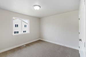 Carpeted empty room featuring baseboards