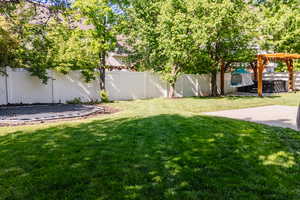View of yard with a trampoline, a patio, and a pergola