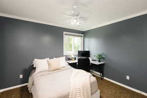 Carpeted bedroom with baseboards, ornamental molding, ceiling fan, and an office area