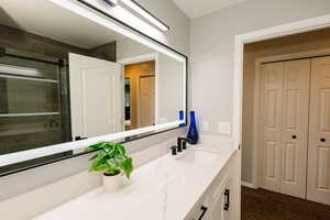 Bathroom featuring vanity, a closet, and an enclosed shower