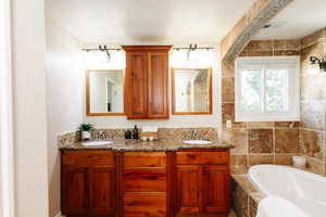 Full bath with a bath and double vanity