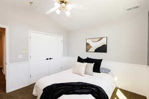 Carpeted bedroom featuring lofted ceiling, a closet, and ceiling fan