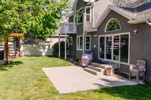 Back of property featuring stucco siding, a balcony, a patio, and entry steps