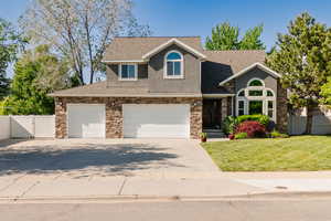 View of front of house with stucco siding, a gate, a garage, roof with shingles, and driveway