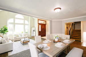 Dining room with stairway, crown molding, wainscoting, and a decorative wall