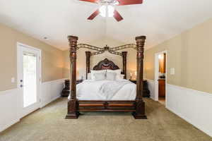 Bedroom featuring light colored carpet, ceiling fan, and vaulted ceiling