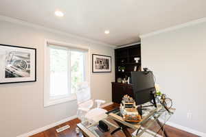 Office space featuring dark wood-style floors, baseboards, crown molding, and recessed lighting