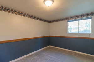 Unfurnished room featuring baseboards and carpet