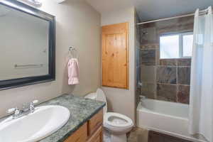 Bathroom featuring toilet, bathing tub / shower combination, and vanity