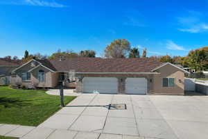 Ranch-style home featuring brick siding, concrete driveway, an attached garage, and a gate