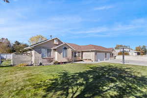 Ranch-style home with brick siding, driveway, a garage, and stucco siding