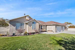 View of front of house with brick siding, concrete driveway, a garage, and stucco siding