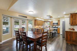 Dining space featuring dark wood finished floors, baseboards, and recessed lighting
