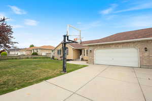 View of front facade featuring an attached garage, concrete driveway, and brick siding