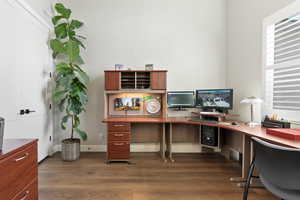 Office with wood finished floors and healthy amount of natural light