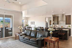 Living room with light wood finished floors, ceiling fan, a chandelier, recessed lighting, and baseboards