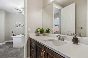 Bathroom with ceiling fan, vanity, and baseboards