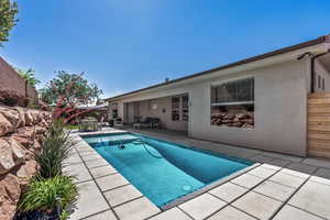 View of pool featuring a patio area, fence, and outdoor dining space