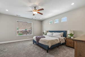 Carpeted bedroom featuring baseboards, a ceiling fan, and recessed lighting