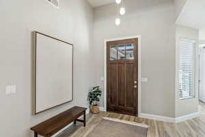 Foyer entrance with light wood-style flooring and baseboards