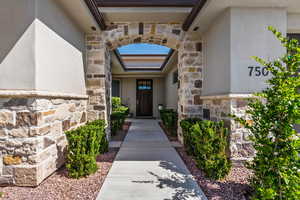 Doorway to property featuring stone siding and stucco siding