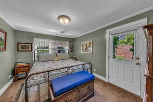 Bedroom with carpet floors, ornamental molding, and baseboards