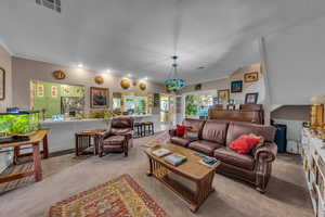 Carpeted living room with ornamental molding and recessed lighting
