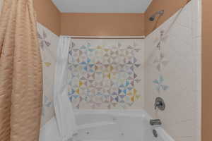 Full bathroom featuring shower / bathtub combination with curtain