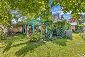 View of yard featuring cooling unit, a pergola, and a patio area