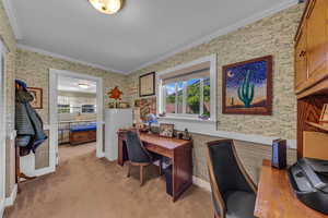 Office space with wallpapered walls, healthy amount of natural light, ornamental molding, and light colored carpet