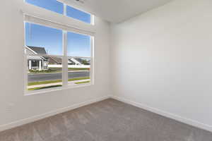 Spare room featuring carpet and baseboards
