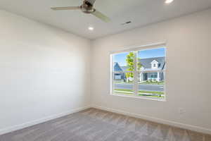 Carpeted spare room featuring baseboards, recessed lighting, and ceiling fan