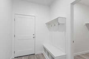 Mudroom with light wood-type flooring and baseboards