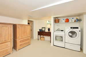 Washroom featuring independent washer and dryer and light carpet