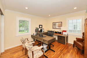 Office space with light wood finished floors, ornamental molding, baseboards, and recessed lighting