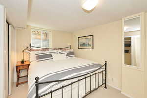 Bedroom featuring light carpet and baseboards