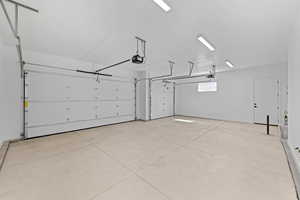 Garage with a garage door opener and baseboards
