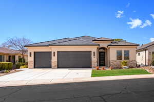 Prairie-style house featuring stone siding, a garage, driveway, and stucco siding