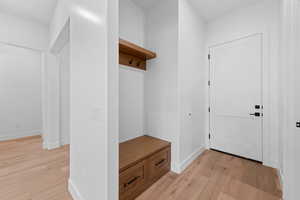 Mudroom with light wood-style floors and baseboards