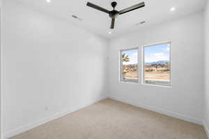 Carpeted empty room featuring a ceiling fan, baseboards, and recessed lighting