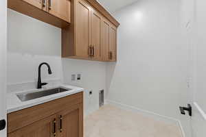 Laundry area featuring electric dryer hookup, hookup for a washing machine, cabinet space, baseboards, and light flooring