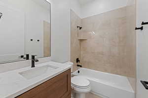 Bathroom with toilet, shower / washtub combination, and vanity