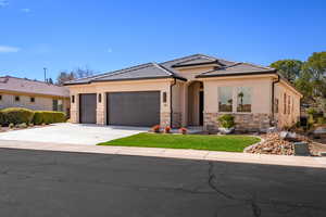 View of front of property featuring an attached garage, stone siding, concrete driveway, stucco siding, and a tiled roof
