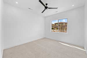 Carpeted spare room with a ceiling fan, baseboards, and recessed lighting